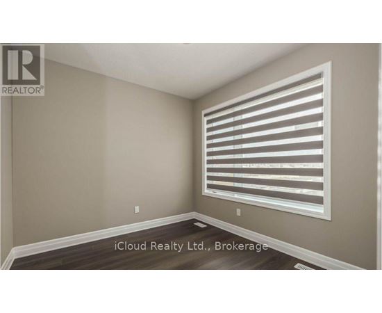 A room with a window covered by horizontal blinds.
