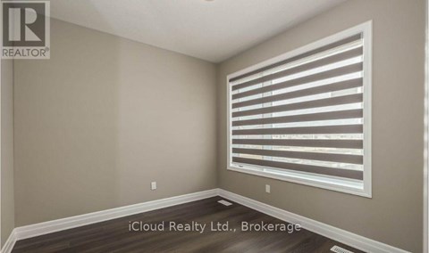 A room with a window covered by horizontal blinds.