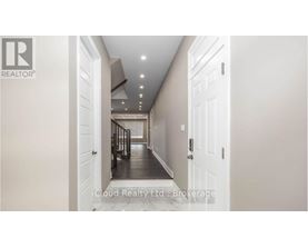 A hallway with white doors and a logo on the wall.
