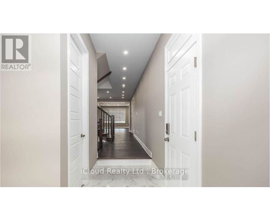 A hallway with white doors and a logo on the wall.