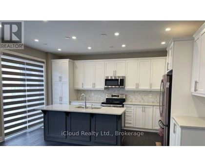 A kitchen with white cabinets and a central island with a sink.