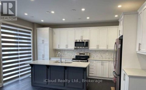 A kitchen with white cabinets and a central island with a sink.