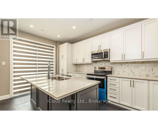 A modern kitchen with white cabinets and a central island.