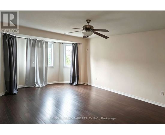 A room with a ceiling fan and sliding doors.