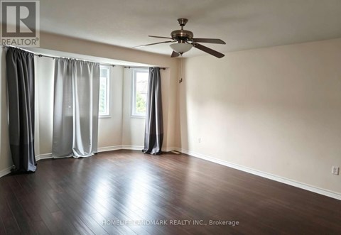 A room with a ceiling fan and sliding doors.