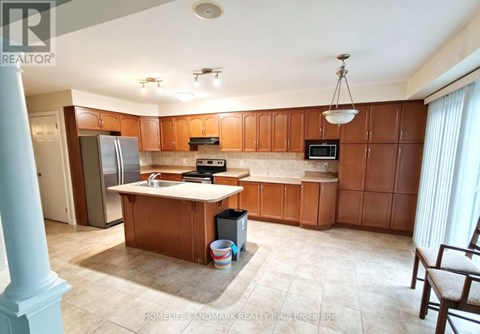 A kitchen with wooden cabinets and a refrigerator.