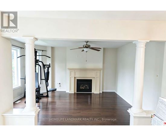 A spacious living room with a fireplace and exercise equipment.
