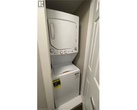 A white dishwasher with the door open is in a small space.