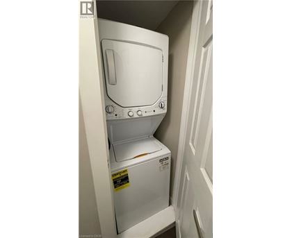 A white dishwasher with the door open is in a small space.