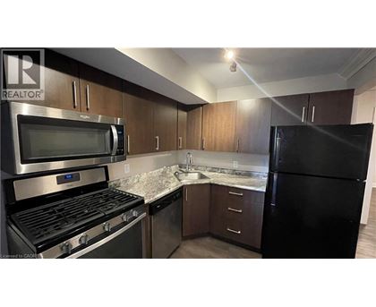 A kitchen with a black fridge, stove, and microwave.