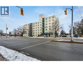 A street view with a building in the background and a REALTOR® logo in the corner.