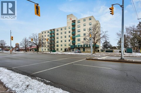 A street view with a building in the background and a REALTOR® logo in the corner.