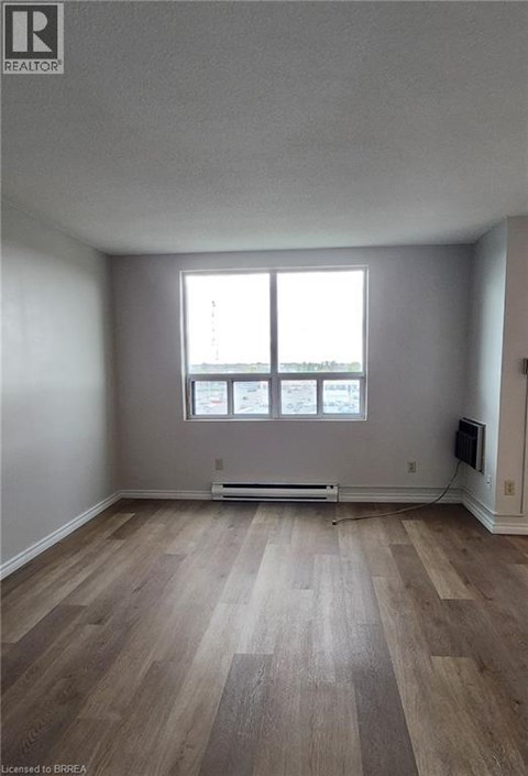 A room with a window and a radiator on the floor.