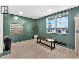 A room with a bench, a window, and a calendar on the wall.