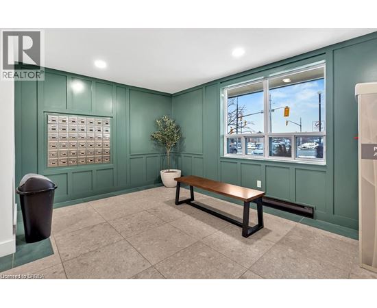 A room with a bench, a window, and a calendar on the wall.