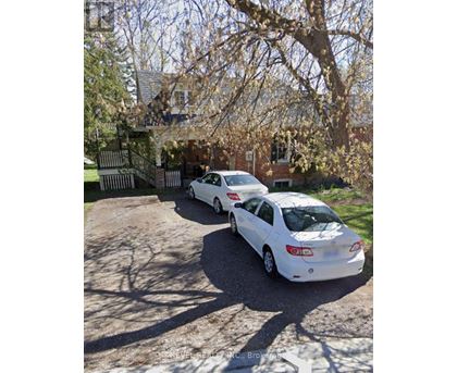 Two white cars parked in front of a house.