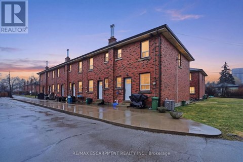 A red brick building with a white door and windows is shown in the image.