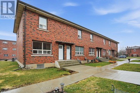 A red brick building with a white door and windows.