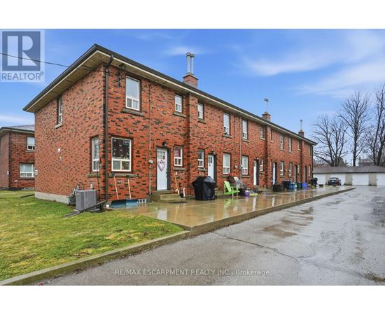 A red brick house with a white door and windows.