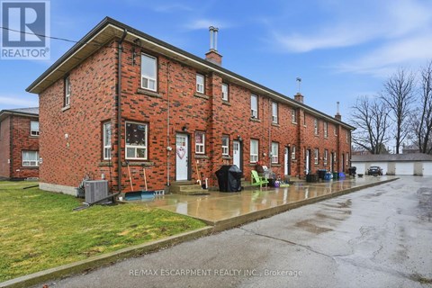A red brick house with a white door and windows.