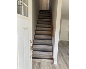 A staircase with wooden steps and a white door.