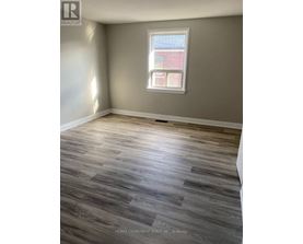 A room with a window and wooden flooring.