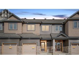 A row of houses with the sign RE/MAX West Realty Inc. Brokerage in front.