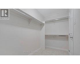 A white bedroom with a door on the right.