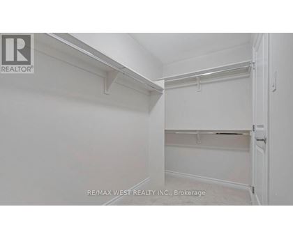 A white bedroom with a door on the right.