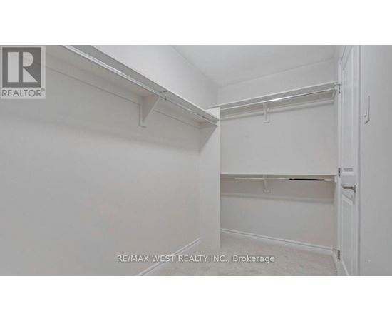 A white bedroom with a door on the right.