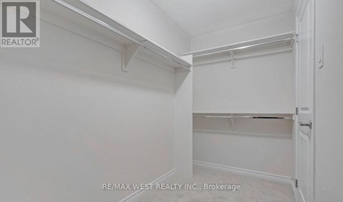 A white bedroom with a door on the right.