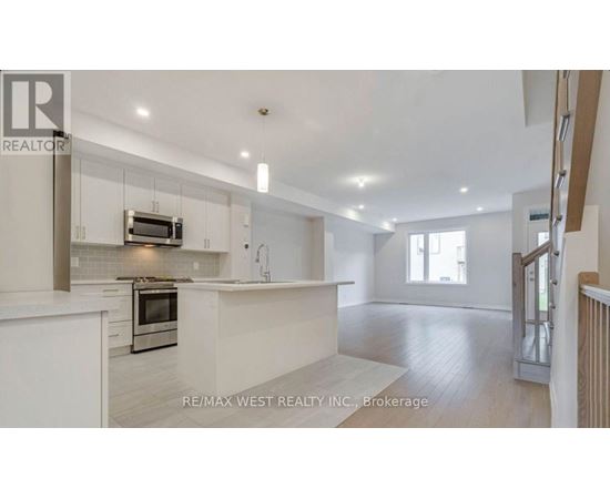 A spacious kitchen with white cabinets and a microwave above the oven.