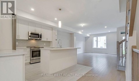 A spacious kitchen with white cabinets and a microwave above the oven.
