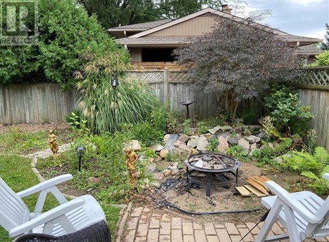 A backyard with a fire pit and chairs.