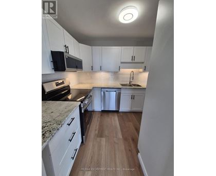 A kitchen with white cabinets and a granite countertop.