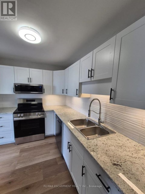 A kitchen with white cabinets and a granite countertop.