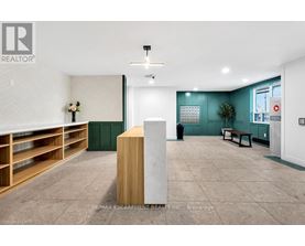 A room with a white ceiling and a wooden floor with a white column in the middle.