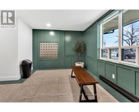 A room with a green wall and a wooden bench.