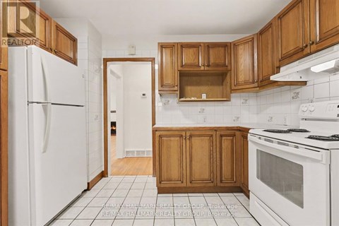 A kitchen with white appliances and wooden cabinets.