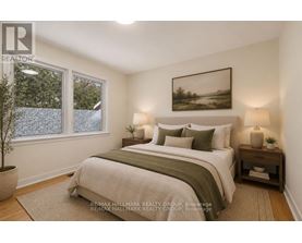 A bedroom with a large bed and a painting on the wall.