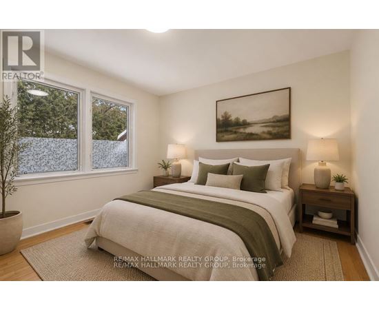 A bedroom with a large bed and a painting on the wall.