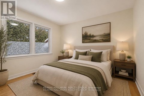 A bedroom with a large bed and a painting on the wall.