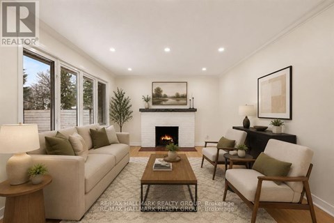 A living room with a fireplace and a painting on the wall.