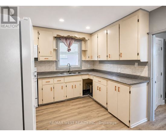 A kitchen with wooden cabinets and a refrigerator.