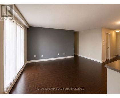 A spacious room with wooden floors and white walls.
