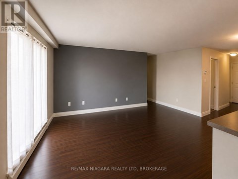 A spacious room with wooden floors and white walls.