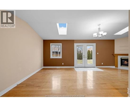 A spacious room with a fireplace and a skylight.