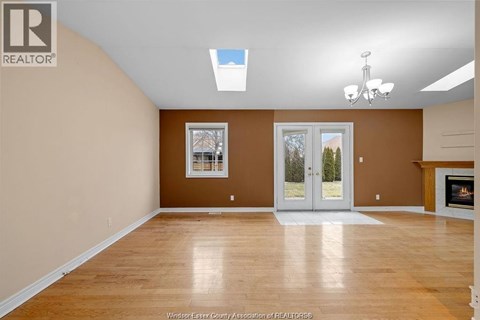 A spacious room with a fireplace and a skylight.