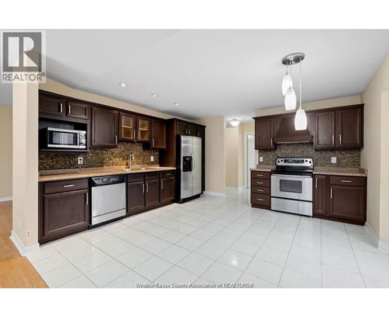 A kitchen with brown cabinets and white appliances.
