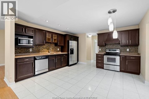 A kitchen with brown cabinets and white appliances.